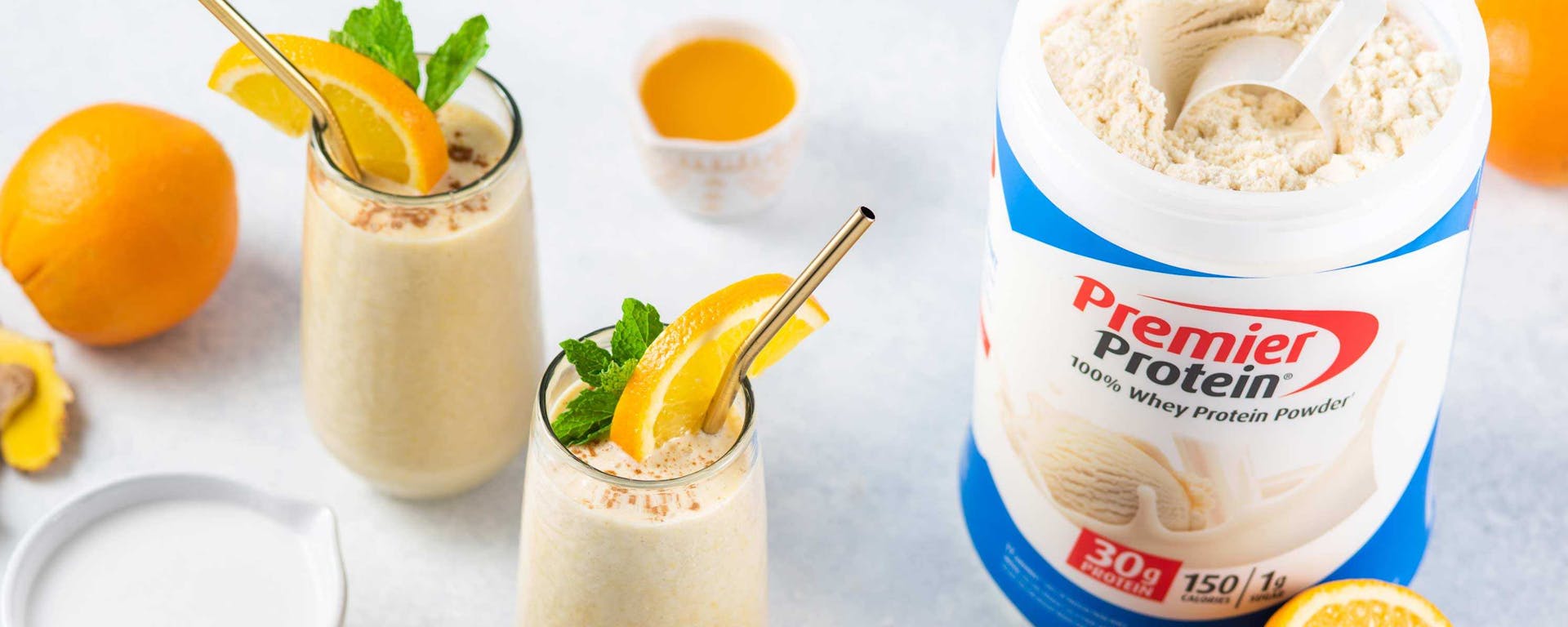 Two Premier Protein shakes in cups made with Premier Protein Vanilla Shake Powder.