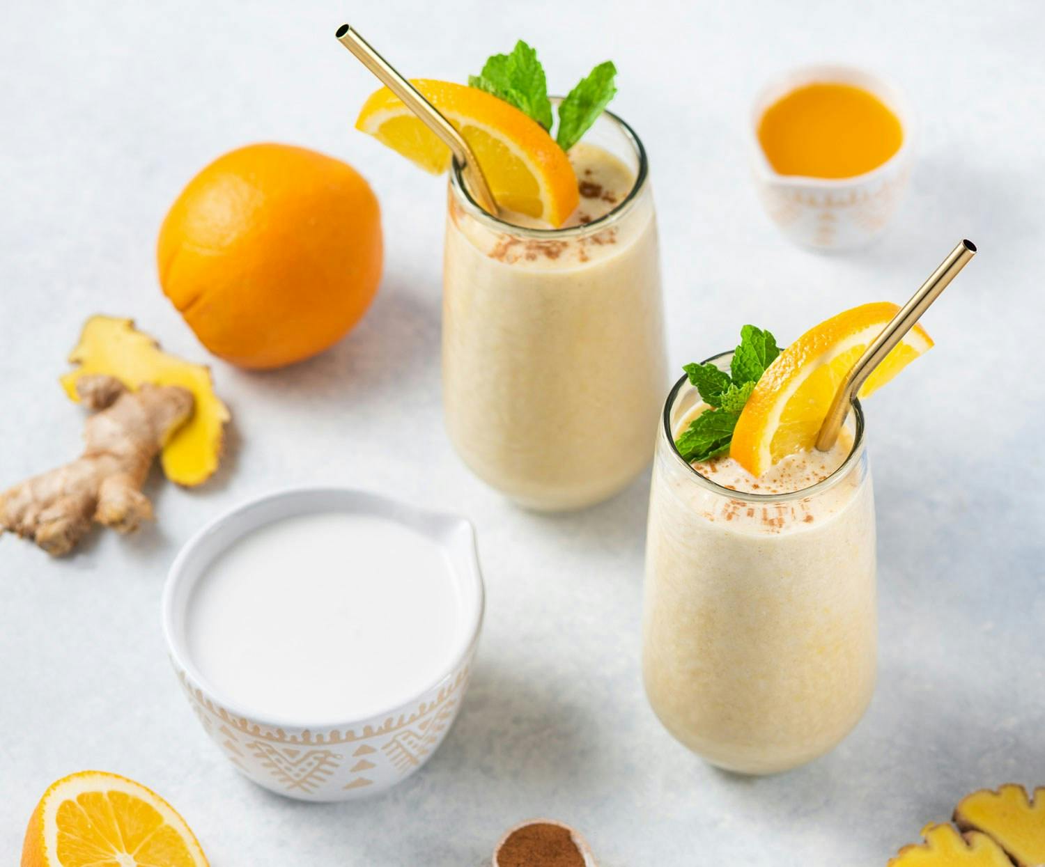Two Premier Protein shakes in cups made with Premier Protein Vanilla Shake Powder.