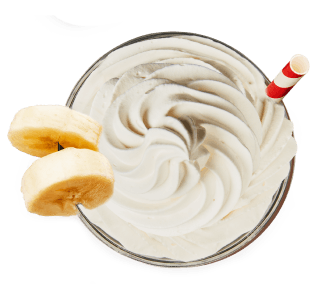 Bananas & Cream protein shake in a glass with straw